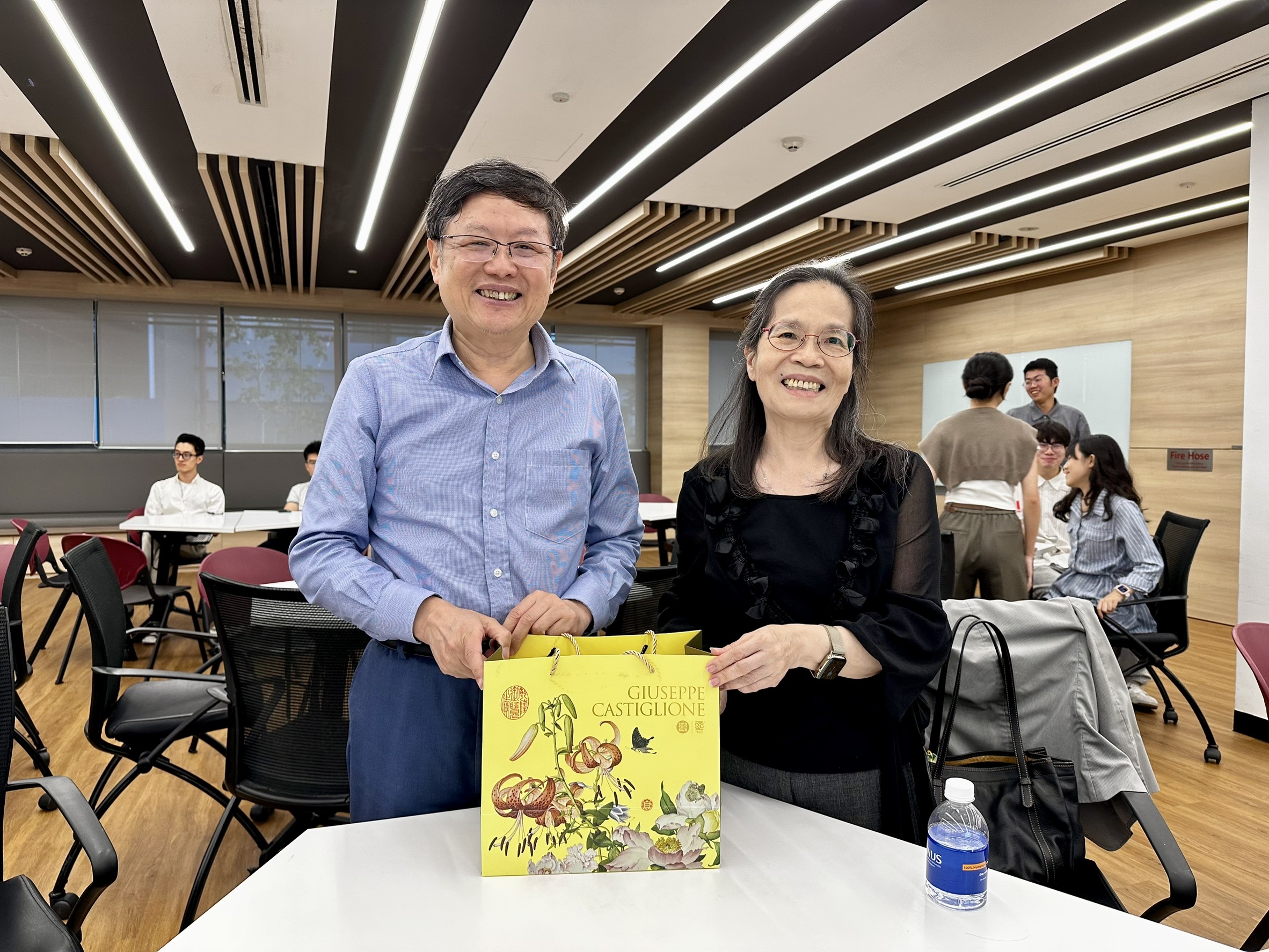 中央大學理學院吳春桂院長(右)與新加坡國立大學理學院SUN Yeneng院長(左)互贈禮物。圖/理學院提供
